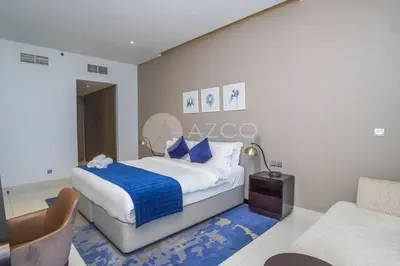 a bedroom with a king sized bed and a couch at Stunning 1 BR Damac Maison Prive in Dubai