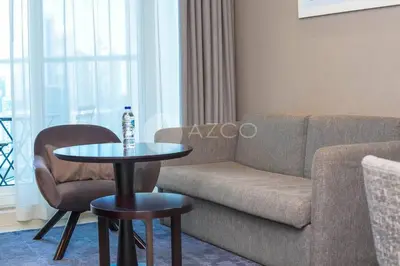 a living room with a couch and a table at Stunning 1 BR Damac Maison Prive in Dubai