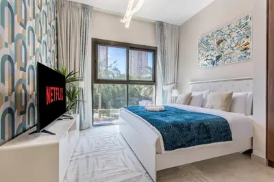 a white bedroom with a large bed and a tv at Holiday Studio In JVC 0107, Dubai in Dubai