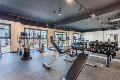 a gym with several treadmills and cardio machines at Holiday Studio In JVC 0107, Dubai in Dubai