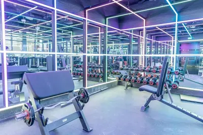 a gym with a chair and rows of dumbbells at Holiday Studio In JVC 2302, Dubai in Dubai