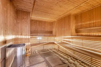 an empty wooden sauna with a trash can in it at Holiday Studio In JVC 2302, Dubai in Dubai