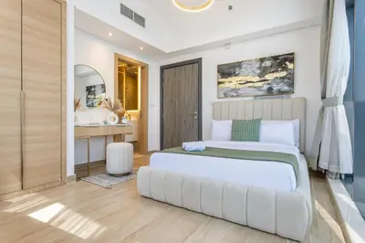 a bedroom with a large bed and a bathroom at Holiday Studio In JVC 2302, Dubai in Dubai