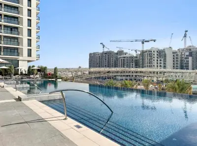 a large swimming pool in a city with buildings at Palace Dubai Creek Harbour Residences Skyline Apartment in Dubai