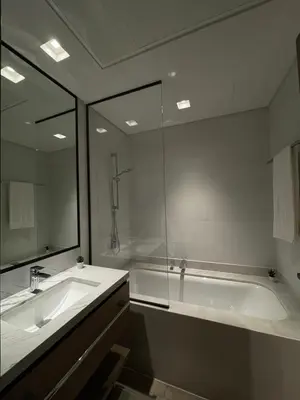 a bathroom with a tub and a sink and a mirror at Palace Dubai Creek Harbour Residences Skyline Apartment in Dubai