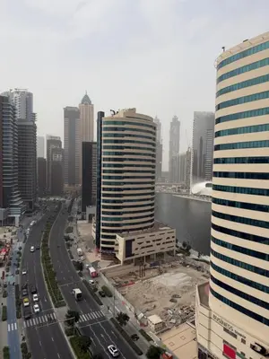 a city skyline with tall buildings and a river at Cozy Spacious AG Tower Business Bay, Dubai in Dubai
