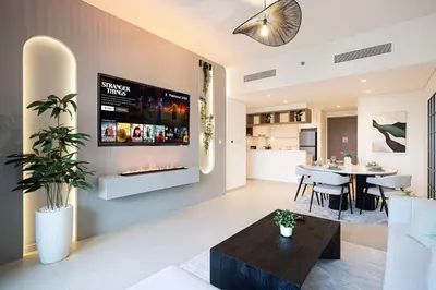 a living room with a fireplace and a dining room at Burj Khalifa View, 2 Balcony w Lounge, Dubai Mall Access, Gym, Infinity-Pool, Playground, BBQ, Family Friendly in Dubai