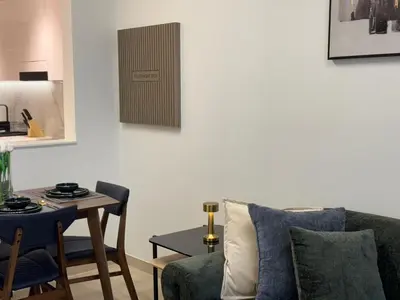 a living room with a couch and a table at ASHRI HH, Luxurious Apt in JVC in Dubai