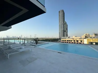 a swimming pool on the roof of a building at ASHRI HH, Luxurious Apt in JVC in Dubai