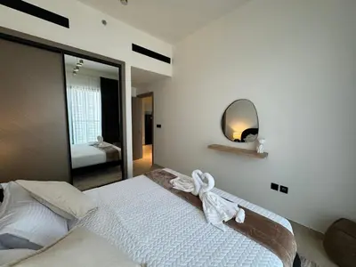 a bedroom with a large bed with a mirror at ASHRI HH, Luxurious Apt in JVC in Dubai