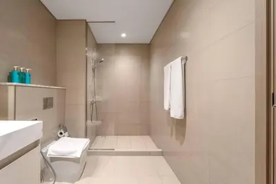 a bathroom with a shower and a toilet and a sink at Mesmerizing view of Burj Khalifa in Dubai