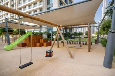 a playground with swings and a slide at Mesmerizing view of Burj Khalifa in Dubai