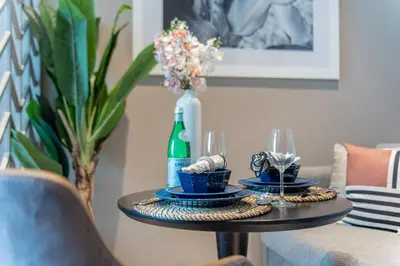 a table with two glasses and a bottle of wine at The Smart Concierge - Damac Maison Prive in Dubai