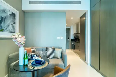 a living room with a couch and a table at The Smart Concierge - Damac Maison Prive in Dubai