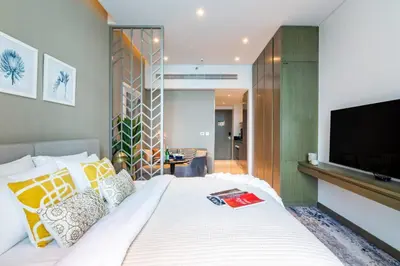 a bedroom with a large bed with a flat screen tv at The Smart Concierge - Damac Maison Prive in Dubai