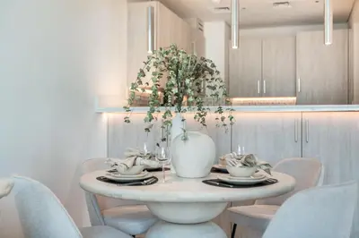 a dining room table with a white vase on it at The Smart Concierge - Seven Palm in Dubai