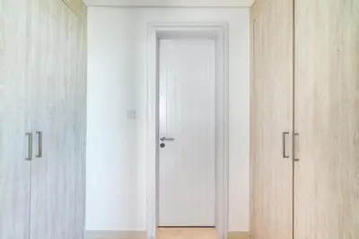 a white door in a room with wooden cabinets at The Smart Concierge - Seven Palm in Dubai
