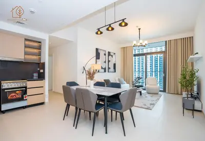 a dining room and living room with a table and chairs at 3 Bedroom Family Apartment from High Floor Downtown Views 183BC-3 in Dubai