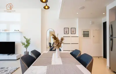 a dining room with a table and chairs at 3 Bedroom Family Apartment from High Floor Downtown Views 183BC-3 in Dubai