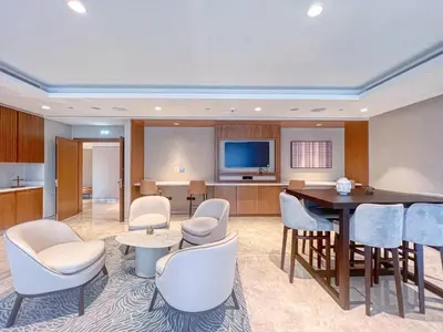a room with a table and chairs and a television at Amazing 2BR Burj Kalifa View in Dubai