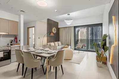 a kitchen and living room with a table and chairs at Amazing 2BR Burj Kalifa View in Dubai
