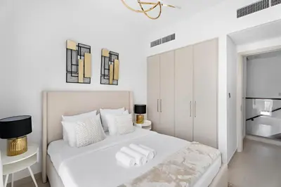 a white bedroom with a white bed and a mirror at Luxurious 6-Sleeper Villa with Large Outdoor Patio in Dubai