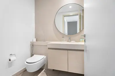 a bathroom with a toilet and a sink and a mirror at Luxurious 6-Sleeper Villa with Large Outdoor Patio in Dubai