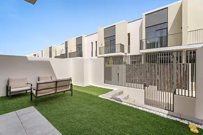 an apartment patio with a bench and grass at Luxurious 6-Sleeper Villa with Large Outdoor Patio in Dubai