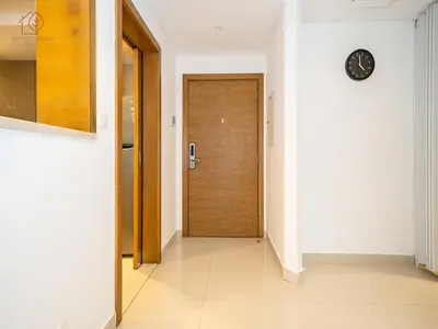 a hallway with a door and a clock on a wall at Spacious 1-Bed Apartment Next to Dubai Mall 157CL2-1 in Dubai