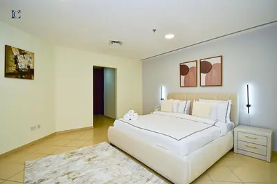 a white bedroom with a large white bed and a rug at Luxury Escapes - Amazing Sea View - 4 Bedrooms Apt with Maids room in JBR in Dubai