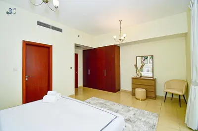 a bedroom with a bed and a table and a chair at Luxury Escapes - Amazing Sea View - 4 Bedrooms Apt with Maids room in JBR in Dubai