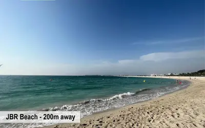a beach with people swimming in the water at Luxury Escapes - Amazing Sea View - 4 Bedrooms Apt with Maids room in JBR in Dubai