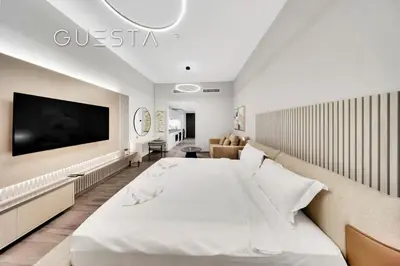 a bedroom with a large bed and a couch at Belgravia Square, Jumeirah Village Circle in Dubai