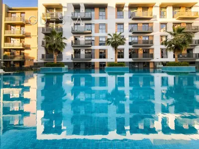 a large swimming pool in front of a building at Belgravia Square, Jumeirah Village Circle in Dubai