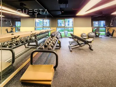 a gym with a row of chairs in a gym at Belgravia Square, Jumeirah Village Circle in Dubai