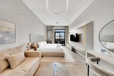 a hotel room with a bed and a couch at Belgravia Square, Jumeirah Village Circle in Dubai