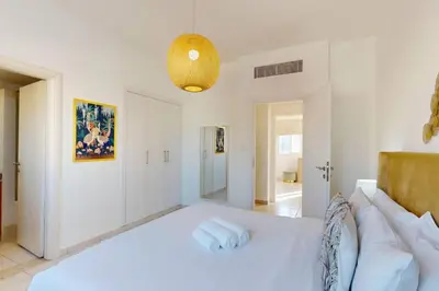 a white bedroom with a bed and a couch at The Springs - Tranquil Two Bedroom Villa in Dubai