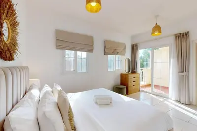 a white bedroom with a large white bed with pillows at The Springs - Tranquil Two Bedroom Villa in Dubai