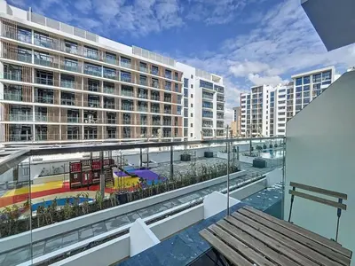 a balcony with a view of a large building at Azizi Riviera 16 - Charming Studio in Dubai