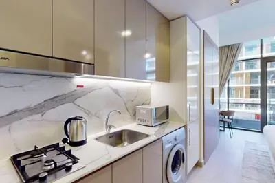 a kitchen with a sink and a stove at Azizi Riviera 16 - Charming Studio in Dubai
