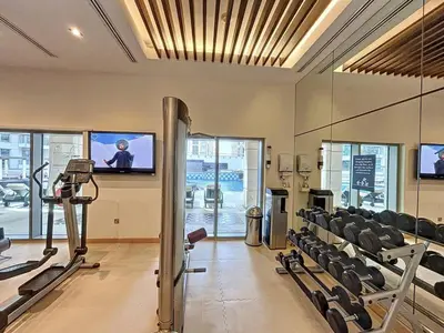 a gym with chairs and a flat screen tv at Standpoint Tower A - Perfect One Bedroom in Dubai