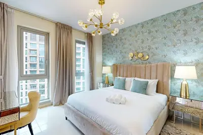a bedroom with a large white bed and a chandelier at Standpoint Tower A - Perfect One Bedroom in Dubai