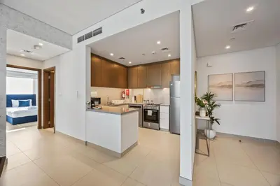 a kitchen with white walls and wooden cabinets at 5242 Tower 2 - Chic Two Bedroom in Dubai