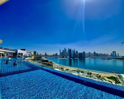 a large swimming pool with a city skyline in the background at Seven Palm Studio with Rooftop Infinity Pool in Dubai