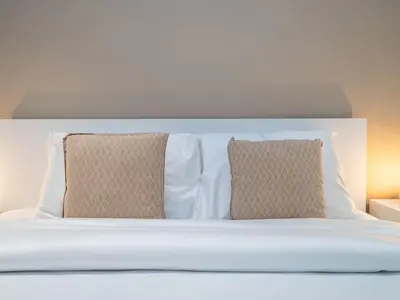 a white bed with two pillows on top of it at Seven Palm Studio with Rooftop Infinity Pool in Dubai