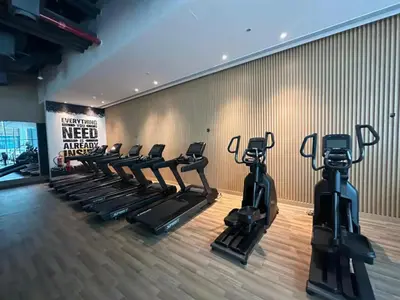 a gym with rows of tread machines in a room at Seven Palm Studio with Rooftop Infinity Pool in Dubai