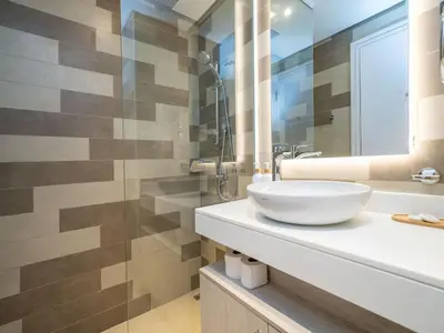 a bathroom with a white sink and a mirror at Seven Palm Studio with Rooftop Infinity Pool in Dubai