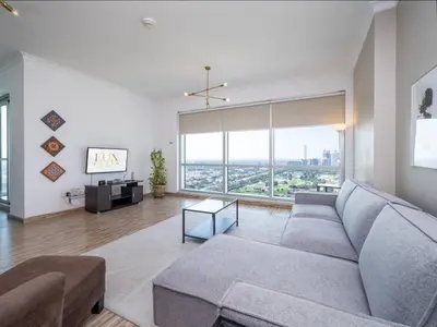 a living room with a couch and a large window at 2 Bedroom Delight in The Greens Dubai in Dubai