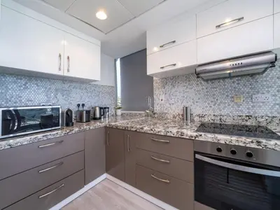 a kitchen with white cabinets and granite counter tops at 2 Bedroom Delight in The Greens Dubai in Dubai