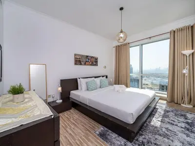 a bedroom with a large bed and a large window at 2 Bedroom Delight in The Greens Dubai in Dubai